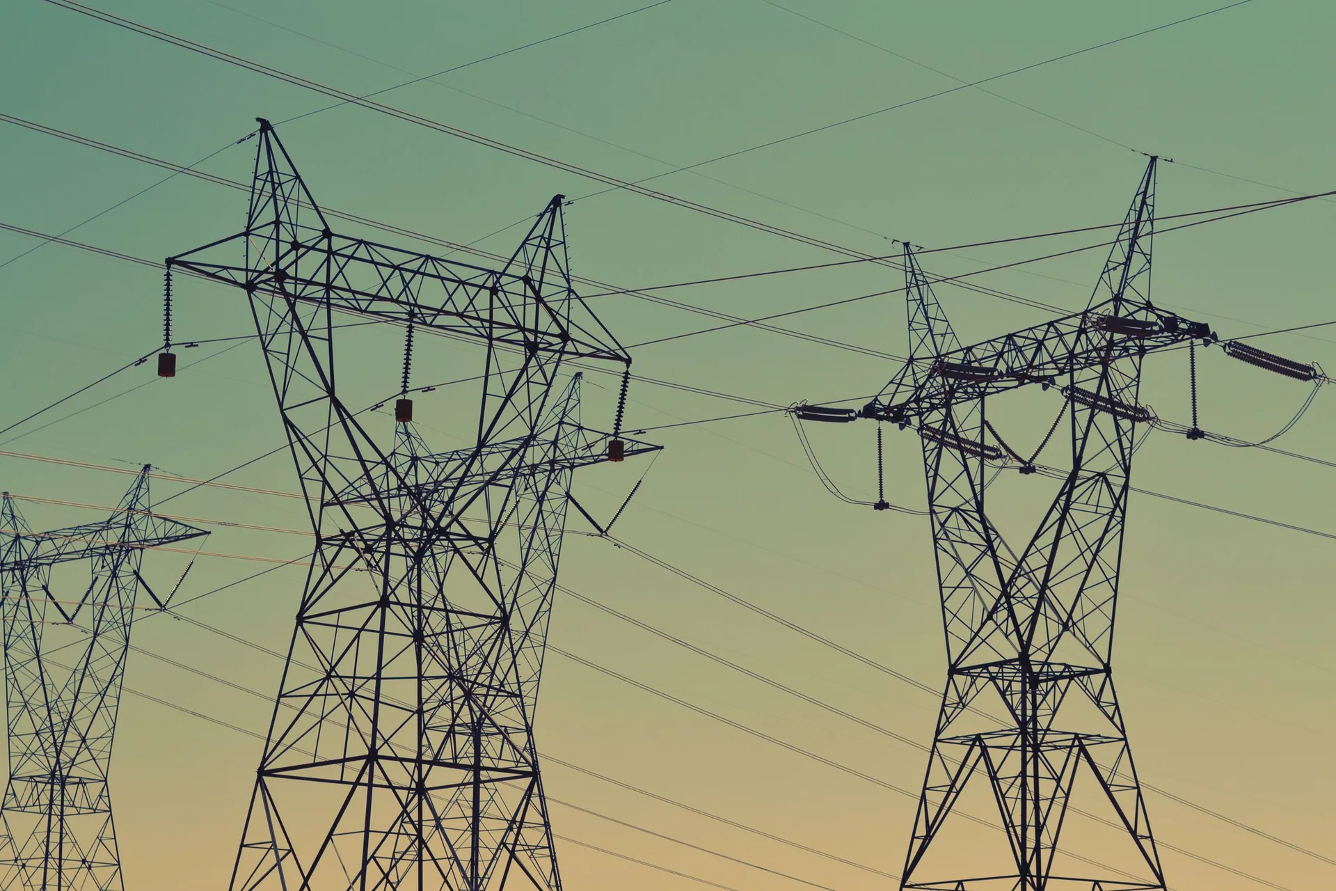 Power transmission lines beneath a bright sky